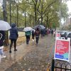 People holding umbrellas and wearing rain jackets wait to cast their ballots at West Side High School on the Upper West Side.