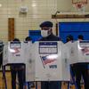 A man votes at a booth inside the gym at P.S. 93 in Brooklyn.