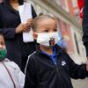 Two young students wear face masks as they arrive for the first day of school.