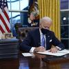 President Joe Biden signs his first executive order in the Oval Office of the White House on Wednesday, Jan. 20, 2021, in Washington. 