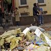 Residents of Red Hook, Brooklyn, carry food and water distributed by the National Guard passed piles of debris, Friday.