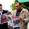 Tunisian men read the newspaper on Janaury 18, 2011 at the Kasbah in Tunis.
