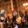 Anti-government protesters raise their shoes after a speech by Egyptian President Hosni Mubarek February 10, 2011 in Cairo, Egypt