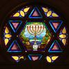 stained glass window in the shape of the Star of David with menorah