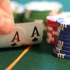 thumb holding up cards with gambling chips