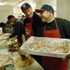 Rich Padula (R) holds a tray of carved turkey beside John Feeney (L) during Thanksgiving preparations at the Bowery Mission 23 November 2005 in New York. Founded in 1879, the facility is the third old
