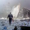 A man with a fire extinguisher walks through rubble after the collapse of the first World Trade Center Tower 11 September, 2001, in New York. The man was shouting as he walked looking for victims who 