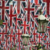 A construction worker stands on a platform amongst the Union Flags in the rafters of Covent Garden installed in honour of the Queen's Diamond Jubilee in London on May 30, 2012.