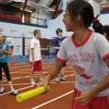 A girl lines up to run carrying a baton wearing a PS107 tshirt