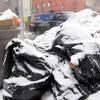 New snow falls on piles of garbage and mountains of old snow in Brooklyn on January 7