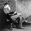 Nikola Tesla in front of the spiral coil of his high-frequency transformer in New York.