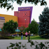 People stand in the parking lot outside the Century 16 movie theater where 12 people were killed in a shooting rampage on July 20 in Aurora, Colorado