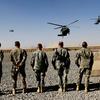 Officers and high-level NCOs wait in line as the helicopter of Commander of U.S. forces in Afghanistan General David Petraeus and his entourage land