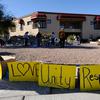 TUCSON, AZ - JANUARY 12: People look at a makeshift memorial outside the office of Rep. Gabrielle Giffords (D-AZ) on January 12, 2011 