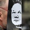 A demonstrator wears a mask depicting the face of the WikiLeaks founder, Julian Assange, during a protest over his arrest, outside the City of Westminster Magistrates' Court in central London