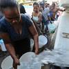 Haitian earthquake victims queue up to get water from a truck in Port-au-Prince on January 18, 2010.