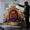Head of Historic Carving Alan Lamb next to the royal cypher that will decorate the Royal Barge in which Britain's Queen Elizabeth II will travel on the River Thames during the diamond jubilee pageant.