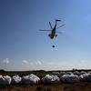 A Louisiana National Guard helicopter carries away sandbags as it takes part in an operation to fortify offshore barrier islands from incoming oil June 1, 2010