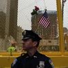 Police officers stand guard at the World Trade Center site where flowers and flags have been left by visitors.