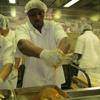 Inmate Nathaniel Harris seasons a turkey before putting it in the oven.