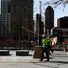 Workers are planting trees and putting in benches at the 9/11 Memorial, World Trade Center,
