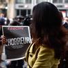 A Sky News journalist holds a French newspaper after a terrorist attack on November 14, 2015 in Paris, France. 