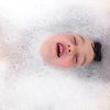 little boy in bathtub surrounded by bubbles at bath time