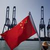 A Chinese flag attached to the back of a boat flaps in the wind as cargo containers sit on the dock of Shenzhen Port on November 28, 2010 in Shenzhen, China.