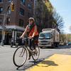 A woman crosses MacDougal street in lower Manhattan on her bicycle