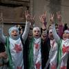 In this photo taken on Wednesday Dec. 21, 2011, anti-Syrian regime protesters flash the victory sign as they wear Syrian revolution flags during a demonstration in the Baba Amr area, in Homs province.