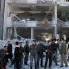 Syrian security officers gather in front the damaged building of the aviation intelligence department, which was attacked by one of two explosions, in Damascus, Syria, on Saturday, March 17, 2012.