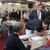 New Jersey Gov. Chris Christie, top, looks on as his son, recent Princeton graduate, Andrew Christie signs in to vote at Brookside Engine Company 1 firehouse in Mendham Township, N.J. on June 7, 2016.