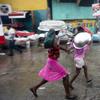 Women cover their heads with pans as they walk in a light rain brought by Hurricane Matthew in Port-au-Prince, Haiti, Tuesday, Oct. 4, 2016. 