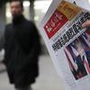 In this Nov. 10, 2016 file photo, a man reads a newspaper with the headline that reads 'U.S. President-elect Donald Trump delivers a mighty shock to America' at a newsstand in Beijing. With Trump's la