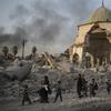 Fleeing Iraqi civilians walk past the heavily damaged Al Nuri mosque in the Old City of Mosul, days before Iraqi forces announced victory.