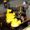 In a photo from Friday, Nov. 17, 2017, in Detroit, River Bistro chef Maxcel Hardy prepares a Caribbean shrimp dish at his restaurant. 