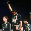 In this Oct. 16, 1968, file photo, Australian silver medalist Peter Norman, stands on the podium as Americans Tommie Smith, center, & John Carlos raise their gloved fists in a human rights protest.