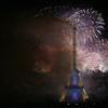 Bastille Day fireworks explode over the Seine river next to the Eiffel Tower in Paris Monday night, July 14, 2014. 