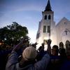 AP10ThingsToSee - Members of the Omega Psi Phi Fraternity lead a crowd of people in prayer outside the Emanuel African Methodist Episcopal Church after a memorial in Charleston, S.C. on  June 19, 2015
