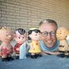 Charles M. Schulz with a few of his Peanuts characters, including (from left) Linus (with blanket) Lucy van Pelt, Charlie Brown, and Snoopy. Image dated January 1, 1962.