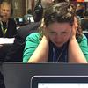 WNYC's Brigid Bergin holds her headphones close to her ears while sitting at Media Row on Wednesday at the DNC in Philadelphia.