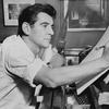 Leonard Bernstein seated at the piano in 1955.