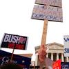 Demonstrators wave signs as they march in front of the US Supreme Court in Washington, DC. December 11, 2000.