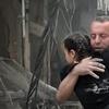 In this image made from video and posted online from Validated UGC, a man carries a child after airstrikes hit Aleppo, Syria, Thursday, April 28, 2016.