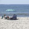 A 'no swimming' sign is seen near Ocean Beach on Fire Island in Islip, N.Y., Thursday, July 19, 2018. Two children were bitten in the leg in the waters off New York's Fire Island 