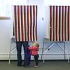 Zoe Buck, 14 mos., looks up at her mother, Julie Buck, as she votes in a booth Tuesday Nov. 4, 2014, at the Alaska Zoo polling place in Anchorage, Alaska.