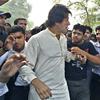 Fugitive opposition leader Imran Khan, second left, is escorted by students representing the hard-line Jamaat-e-Islami party upon his arrival at Punjab University campus in Lahore