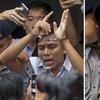 In this combination image made from two photos, Reuters journalists Kyaw Soe Oo, left, and Wa Lone, are handcuffed as they are escorted by police out of the court Monday, Sept. 3, 2018, in Yangon