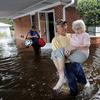 Bob Richling carries Iris Darden, 84, out of her flooded home as her daughter-in-law, Pam Darden, gathers her belongings in the aftermath of Hurricane Florence