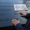 Mohammad Salam places his hands over the engraved names of victims during the 11th anniversary of the terrorist attacks on the World Trade Center, Tuesday, Sept. 11, 2012 in New York. 